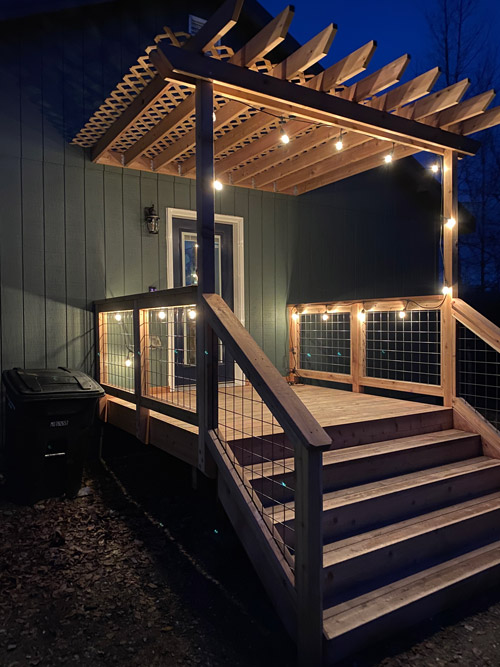 Pergola covered entry way deck lit up at night
